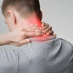 Man holding neck in pain with red area showing inflammation or cervical discomfort