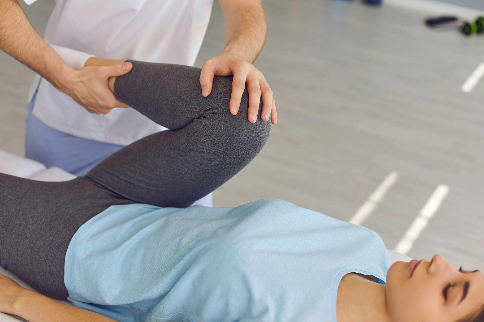 Post-surgical woman receiving physiotherapy exercises from a therapist to aid recovery