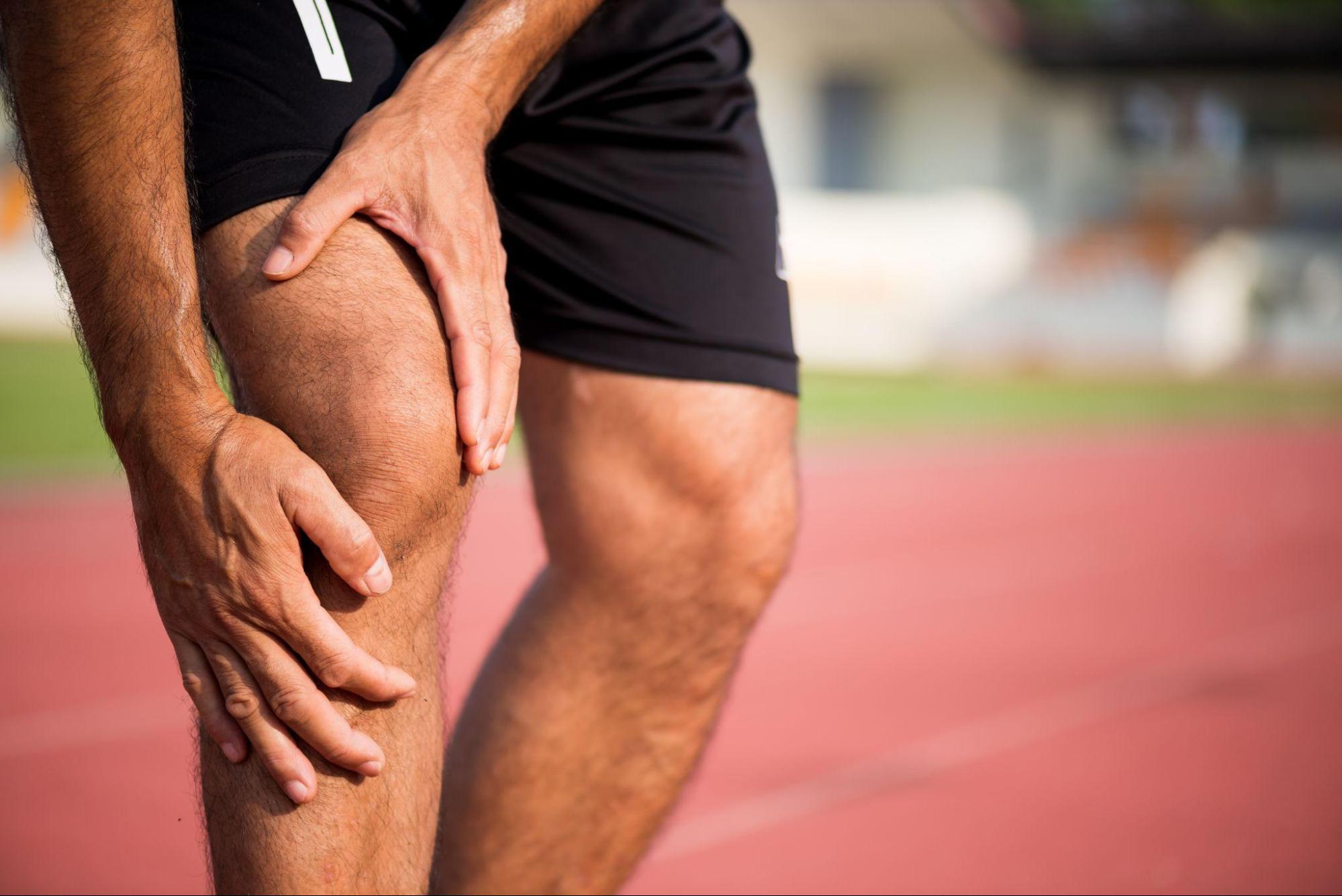 A runner experiencing knee pain, highlighting a common sports injury.