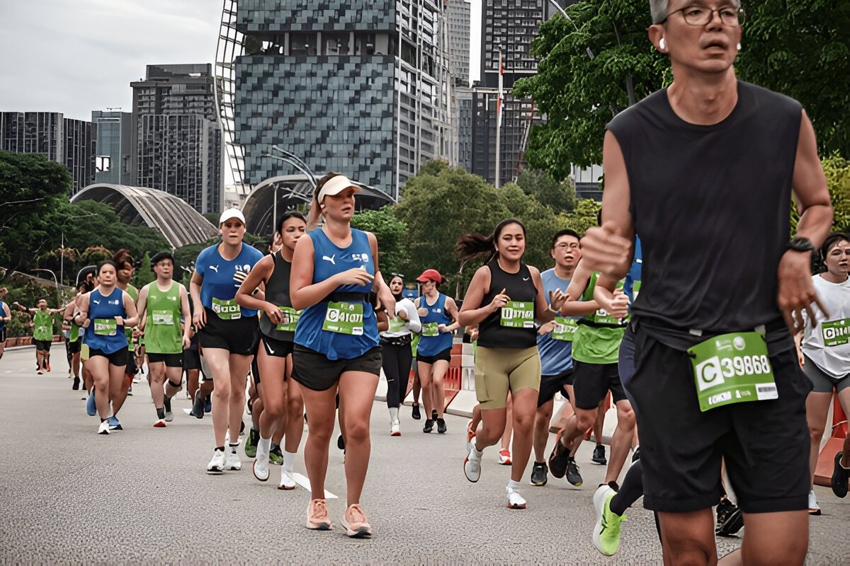 Group of marathon runners in Singapore city during race, wearing bibs and athletic gear.